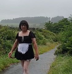 Pembantu rumah transvestite di lorong awam dalam hujan